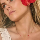 Model in Bixby jewellery. Gold necklace with red hearts 